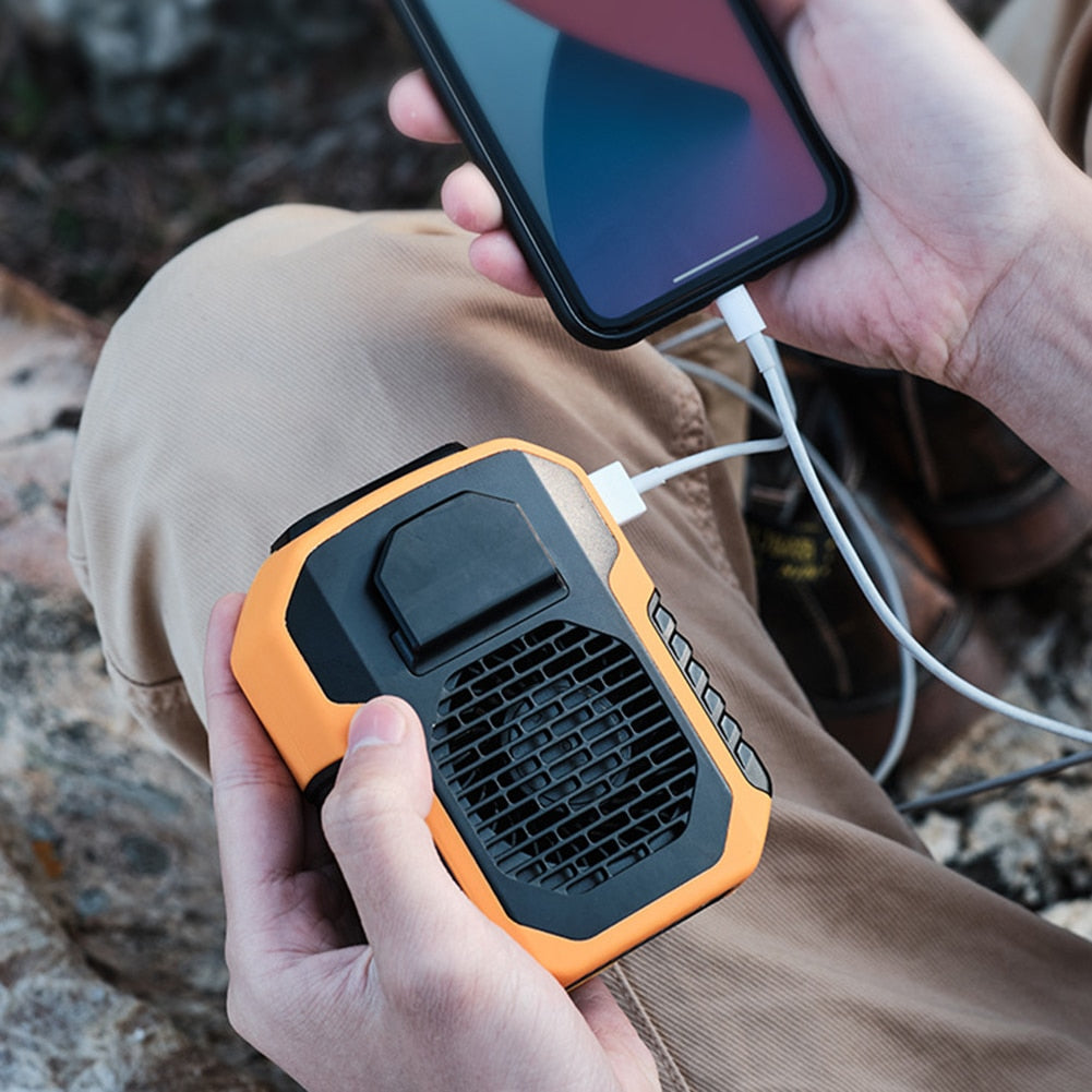 Kvinne bruker hvit håndfri klipsvifte med powerbank festet til ryggsekk utendørs, sommergadget