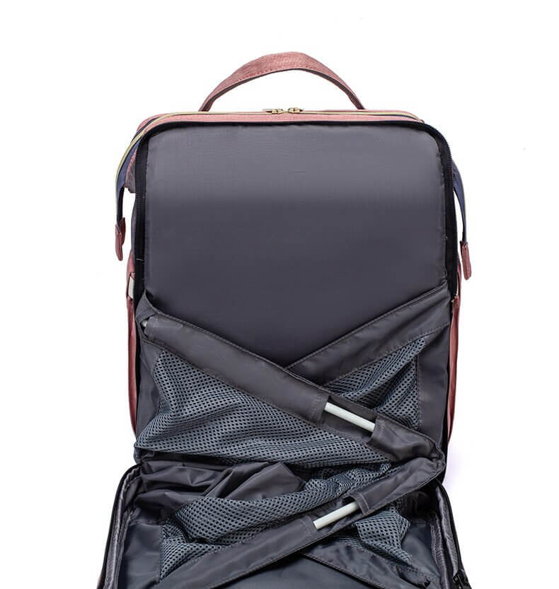 Reisevesken for baby visnende med en flaske og bleier i sidelommen, fremhever funjonalitet som stelleveske.
