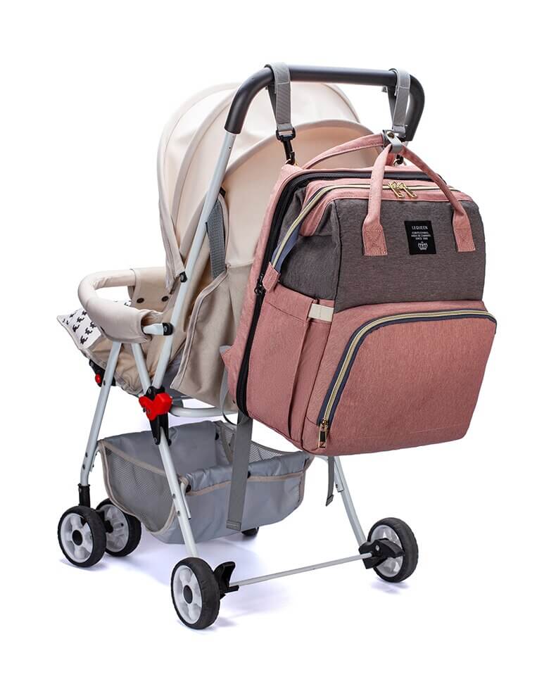 Unisex gave til baby: reiseveske/bleiesekk med integrert seng, presentert med en liten bamse.