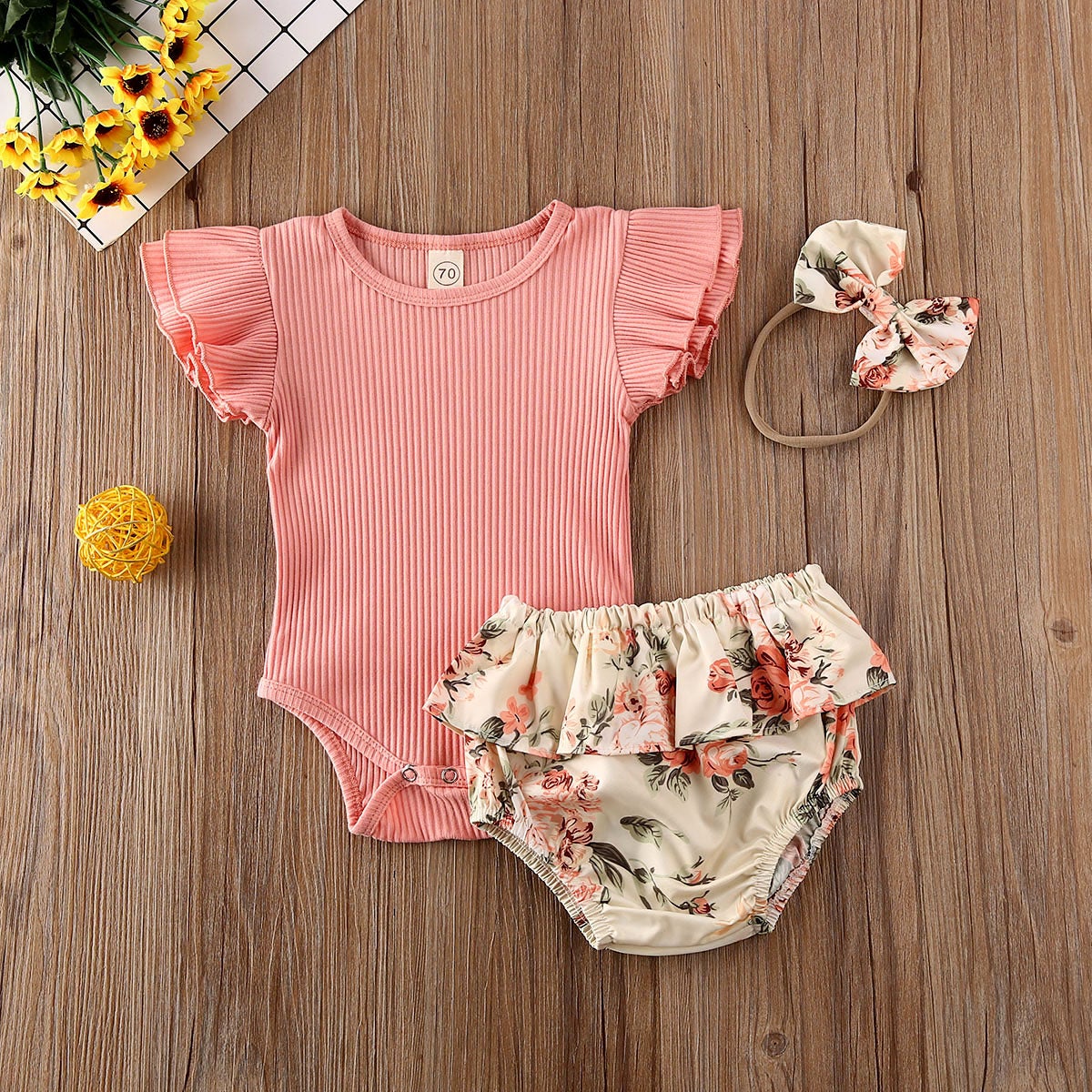 Sommerlig babyjente sett: ribbet body, shorts med volanger og matchende pannebånd, blomstermønster.
