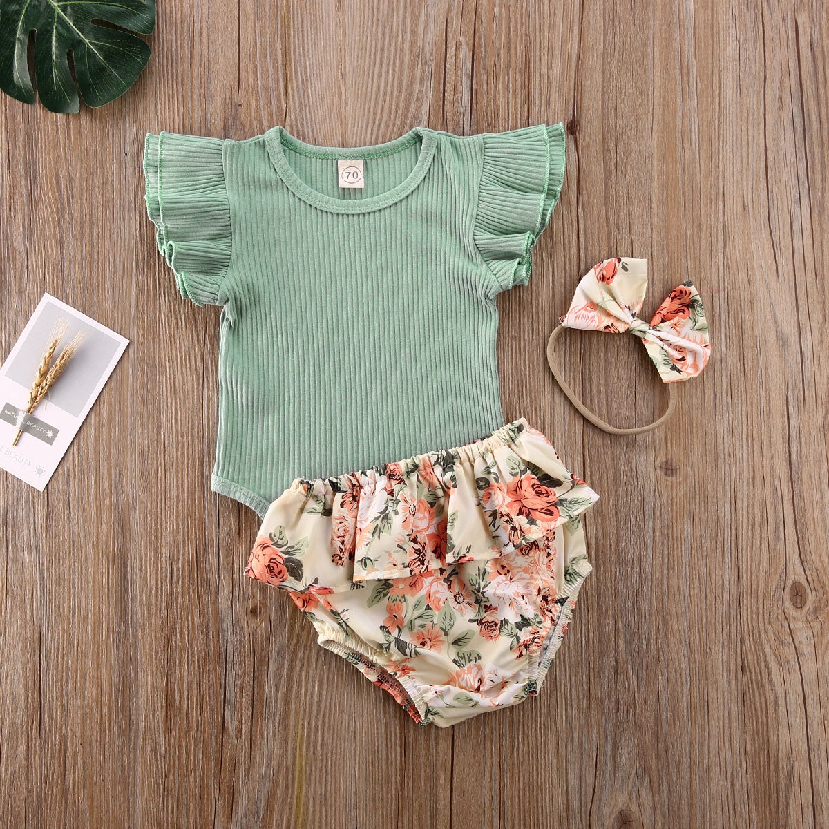 Babyklær jentesett: ribbet body med blomster, volangshorts og pannebånd, moteriktig sommerstil.