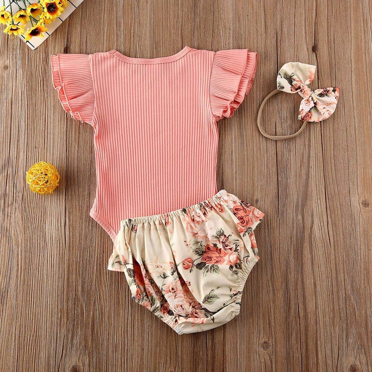 Detaljert bilde av babyjente volang shorts sett med blomster, ribbet body og pannebånd for barnemote.
