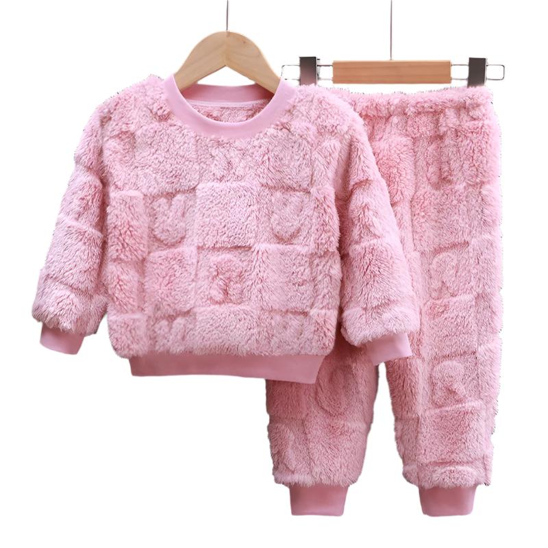 Nærbilde av myk, langermet flanellpyjamas for barn, detaljer av rødt og sort rutemønster.