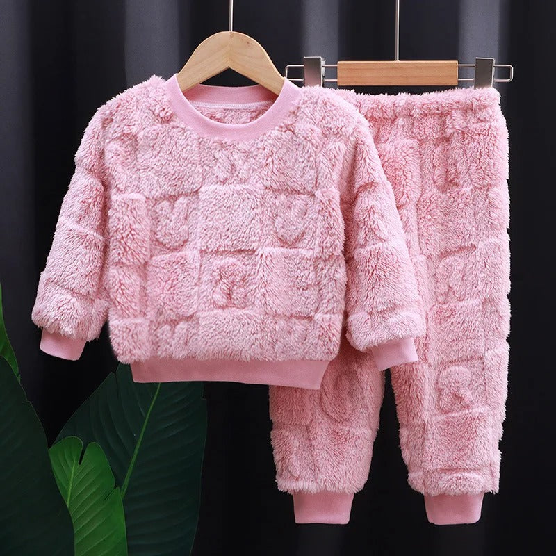 Utsnitt av langermet flanellpyjamas for barn, med knapper og krage, fokus på kvalitet.