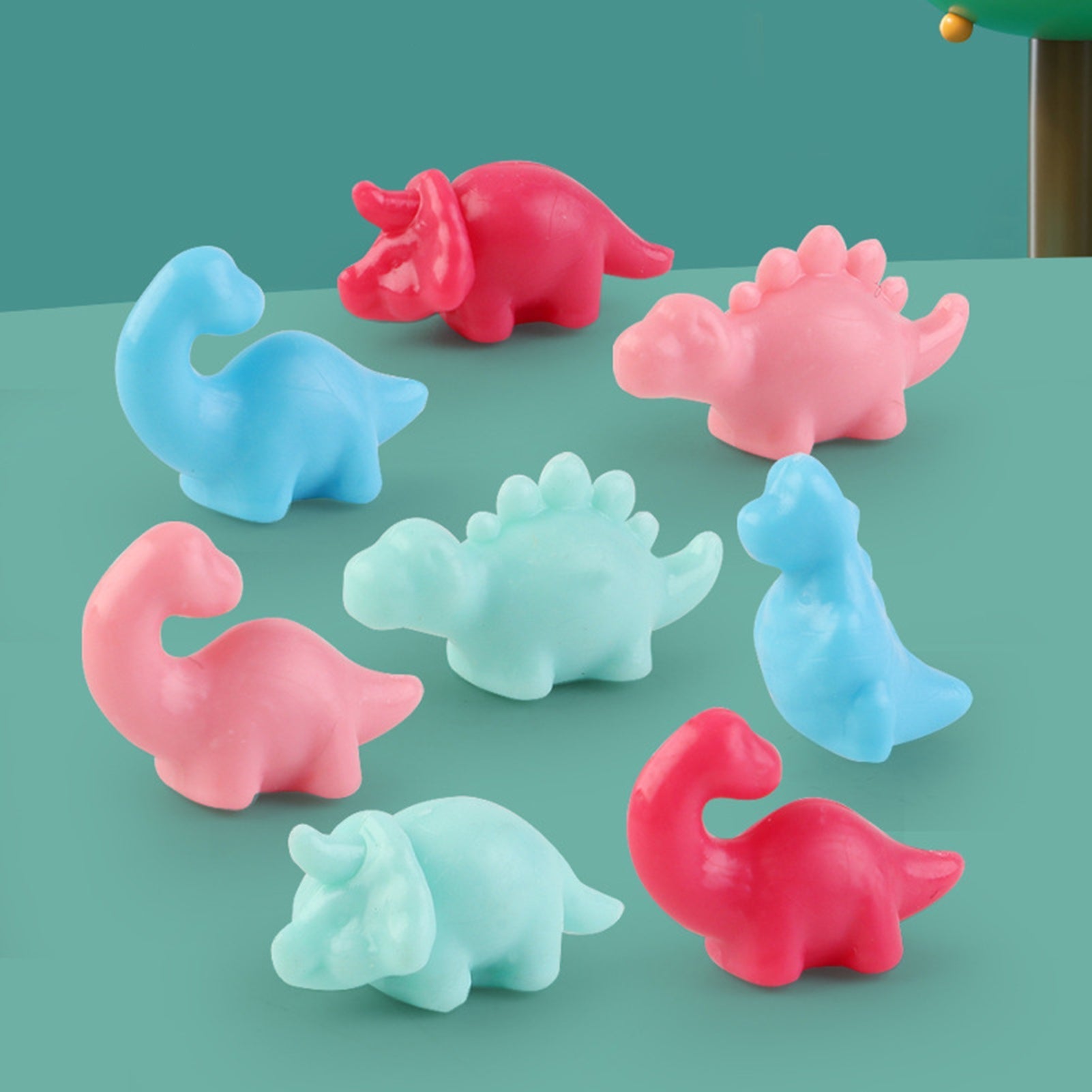 En gutt holder en plastdinosaur han nettopp vant fra en pedagogisk mini klomaskin leke, stimulerende finmotorikk.