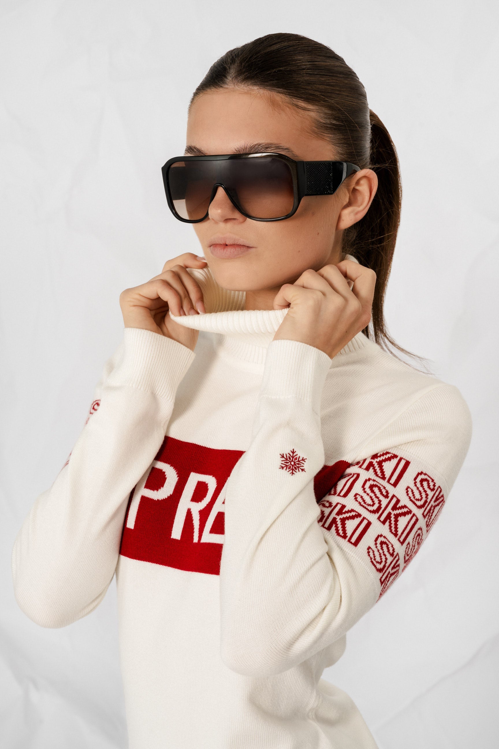"Beige intarsia-strikket APRÈS-SKI genser for damer; ribbestrikket krage, varm og komfortabel til hyttetur og afterski."