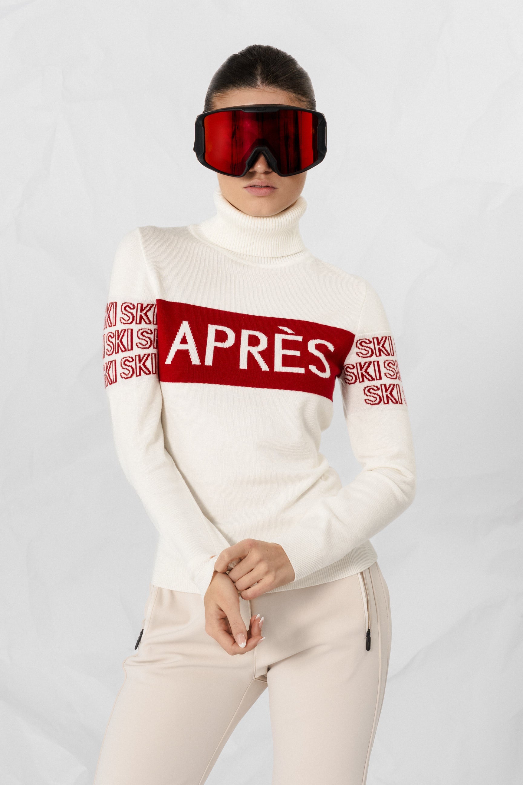 "Beige intarsia-strikket APRÈS-SKI genser for damer; ribbestrikket krage, varm og komfortabel til hyttetur og afterski."