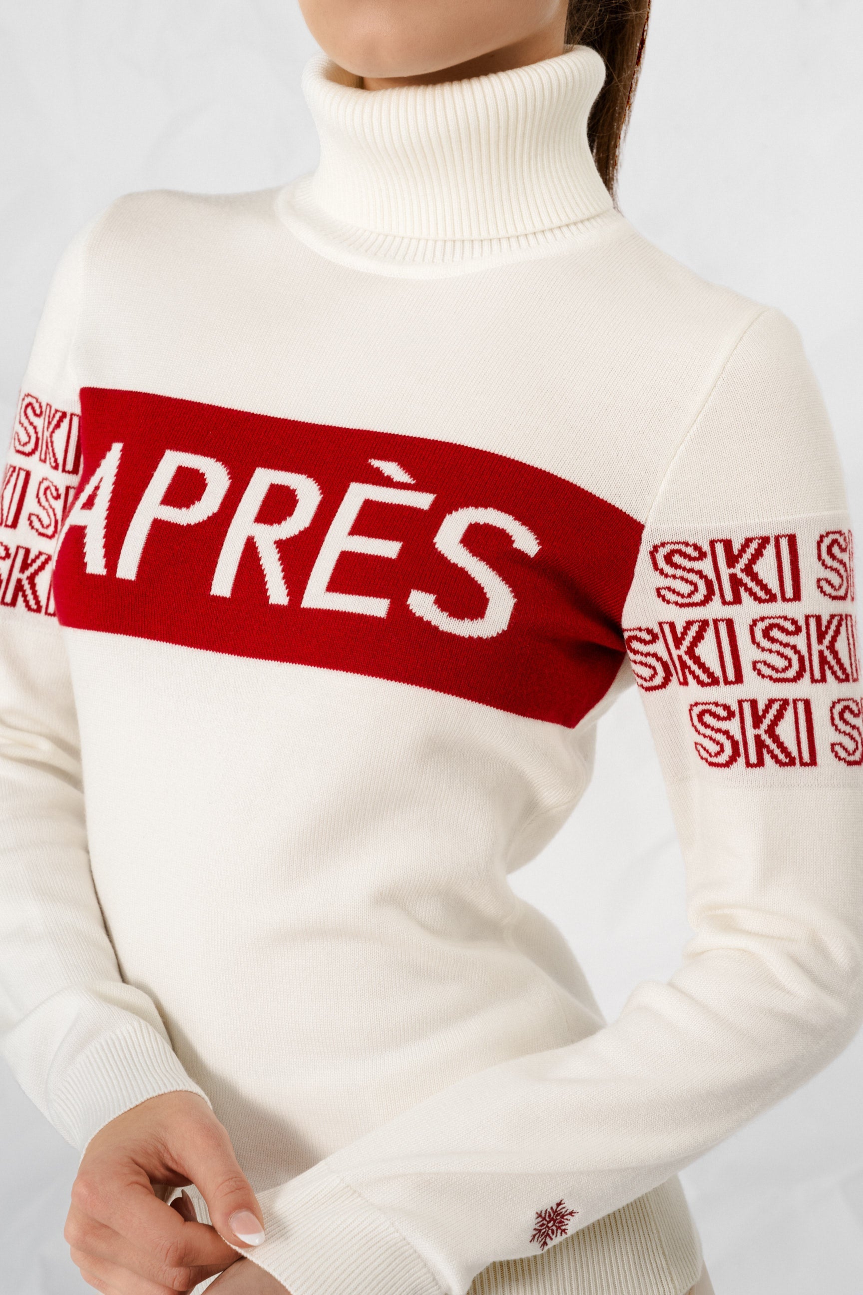 "Beige intarsia-strikket APRÈS-SKI genser for damer; ribbestrikket krage, varm og komfortabel til hyttetur og afterski."