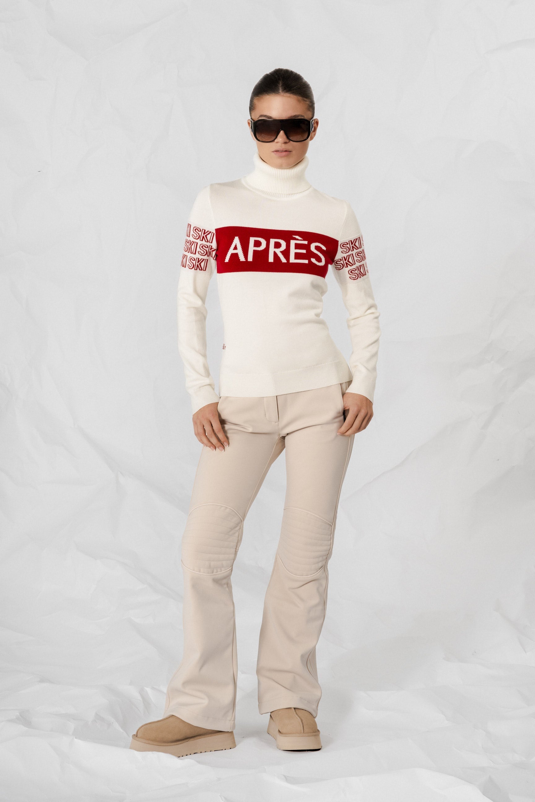 "Beige intarsia-strikket APRÈS-SKI genser for damer; ribbestrikket krage, varm og komfortabel til hyttetur og afterski."
