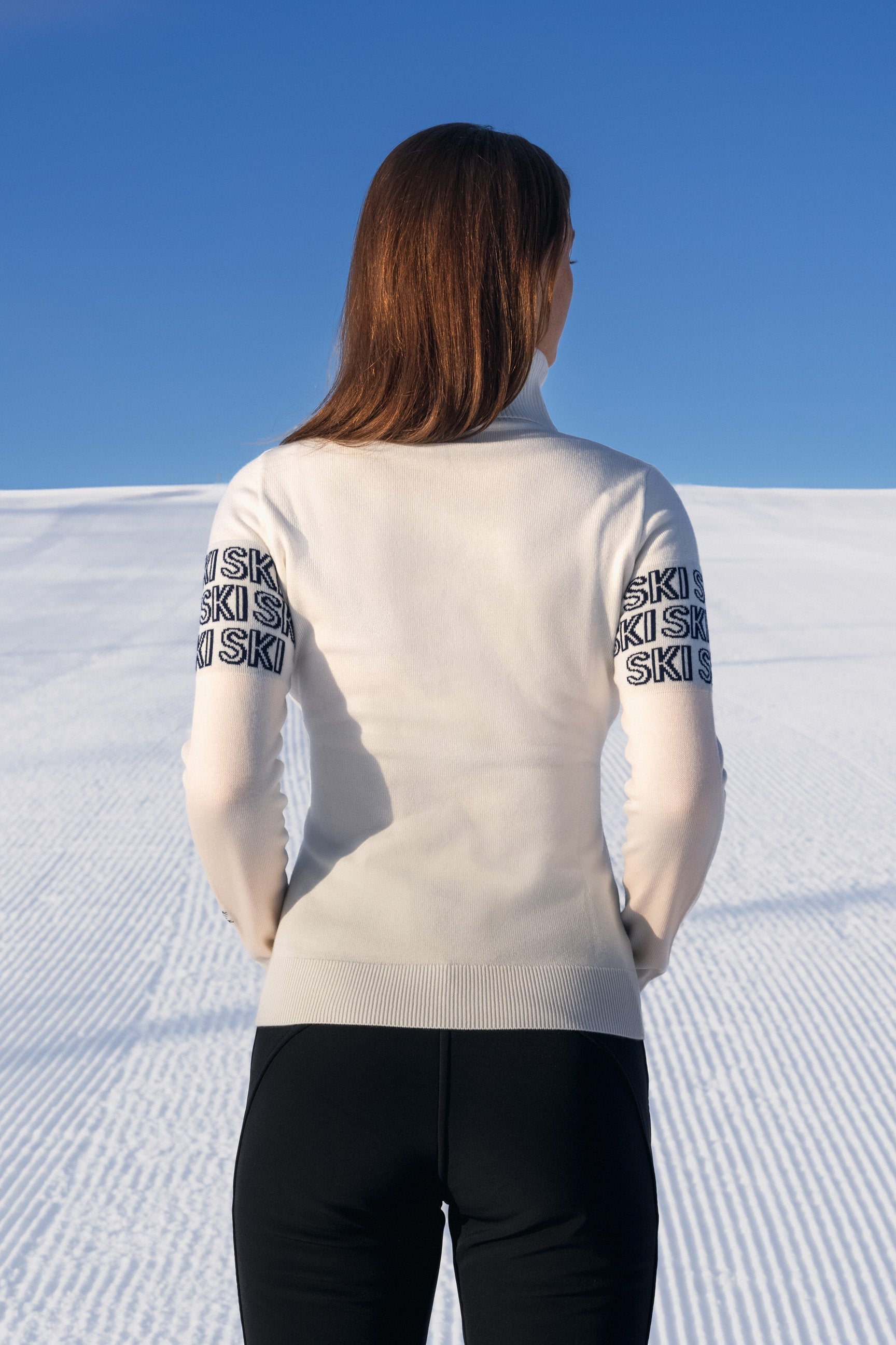 "Beige intarsia-strikket APRÈS-SKI genser for damer; ribbestrikket krage, varm og komfortabel til hyttetur og afterski."