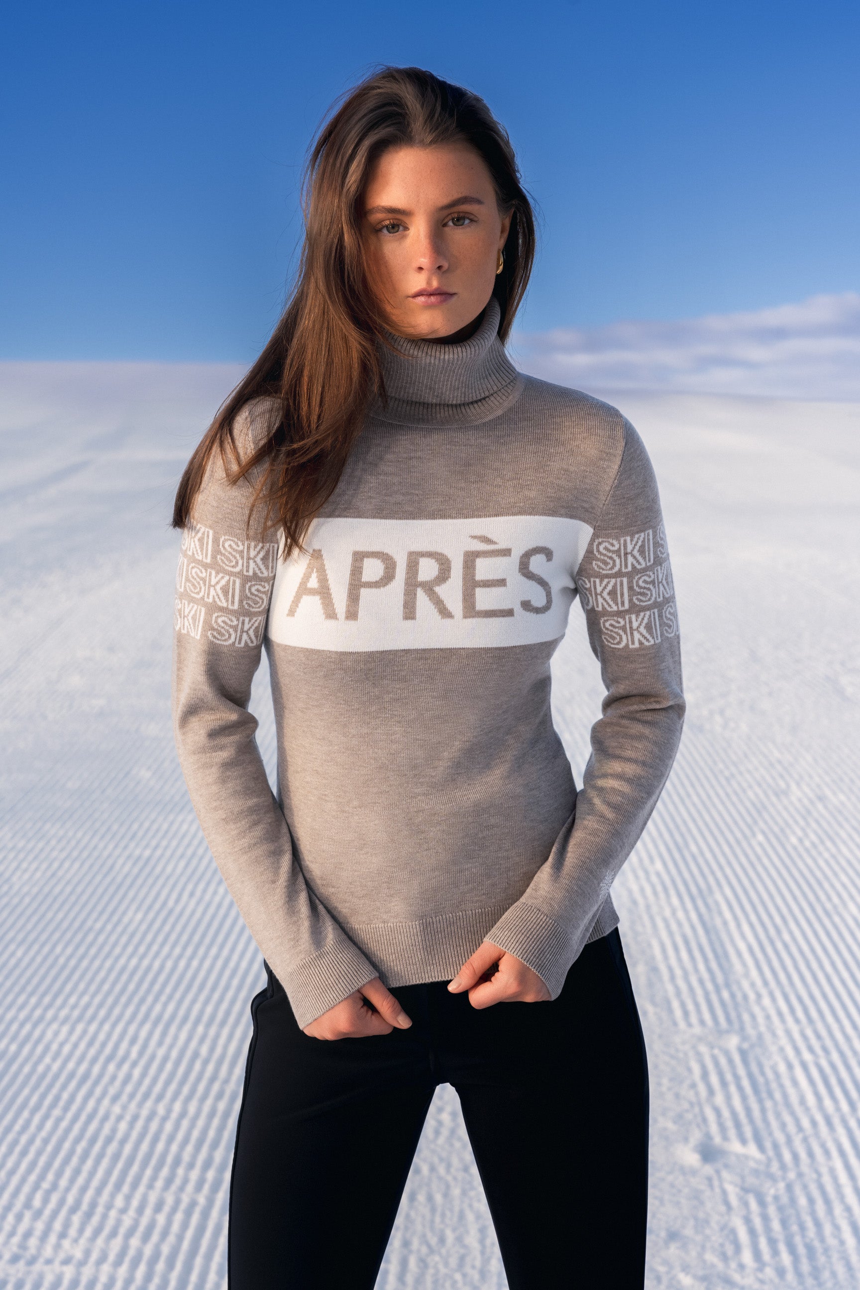 "Beige intarsia-strikket APRÈS-SKI genser for damer; ribbestrikket krage, varm og komfortabel til hyttetur og afterski."