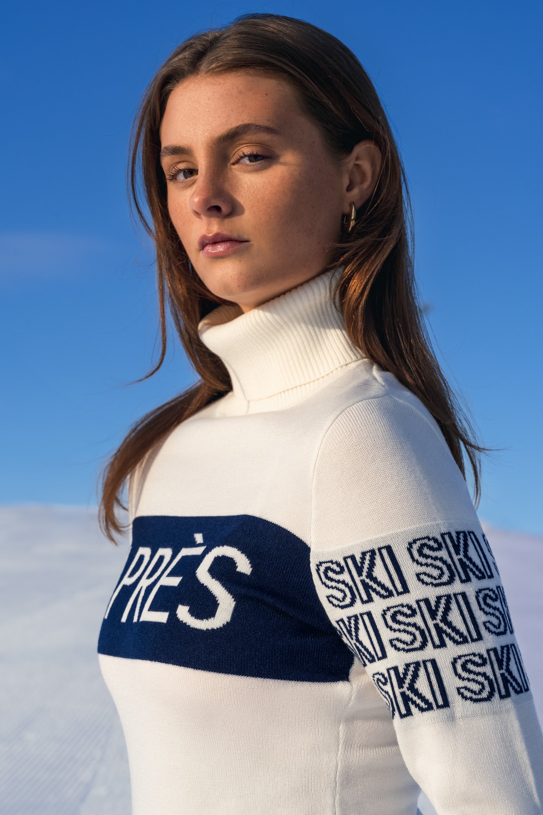 "Beige intarsia-strikket APRÈS-SKI genser for damer; ribbestrikket krage, varm og komfortabel til hyttetur og afterski."