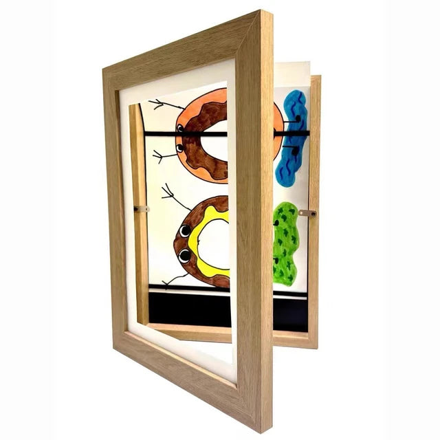 Bilderamme hvit med hengslet front for barnas kunstverk, synlig magnetlås og oppbevaringsplass bak, perfekt for barnerommet