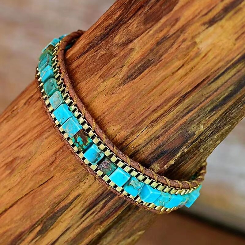 Nærbilde av boho damearmbånd i blågrønne nyanser med naturlige steiner, ideelt for festivalstil.