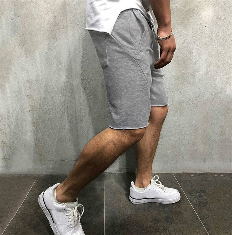 Nærbilde av ledige herreshorts med justerbar snøring og elastisk linning for god passform.