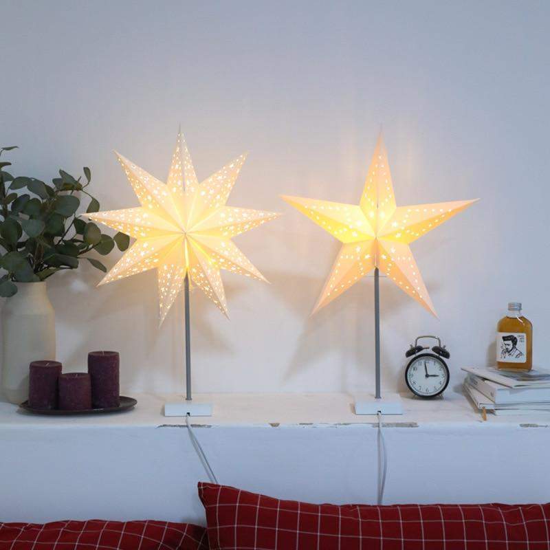 Nærbilde av bordlampe med stjernemotiv og solid trebase, ideell som dekorativ belysning.