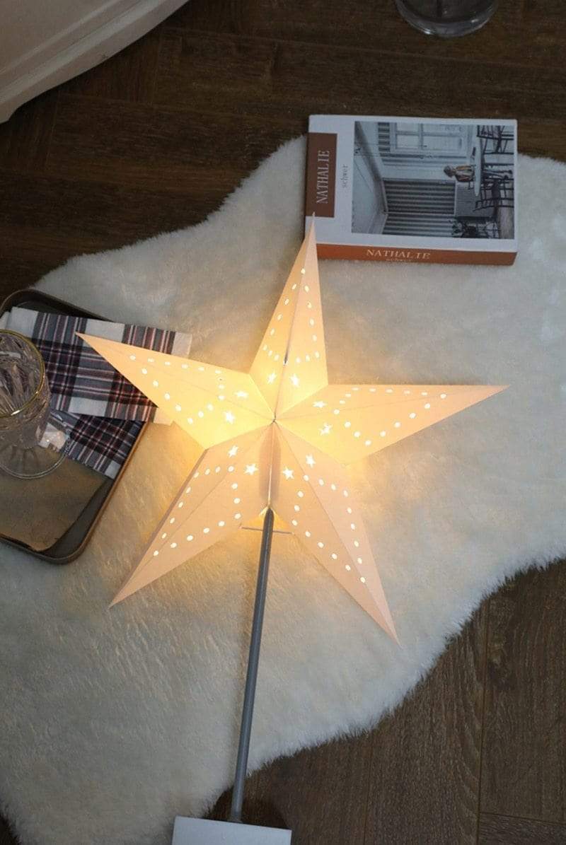 Bordlampe med stjernedesign på et nattbord, fungerer som en funksjonell og dekorativ nattlampe.