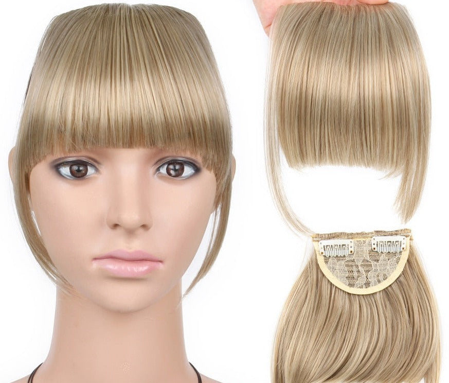 Clip-in lugg i lys blond, skaper en mykere ansiktsform uten klipp.