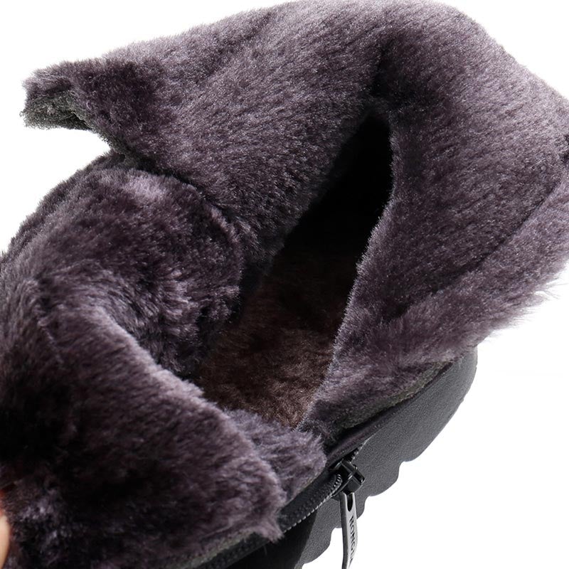 Par dame vinterstøvler med plysfor, synlig varme, og sklisikre såler, klar for snø.