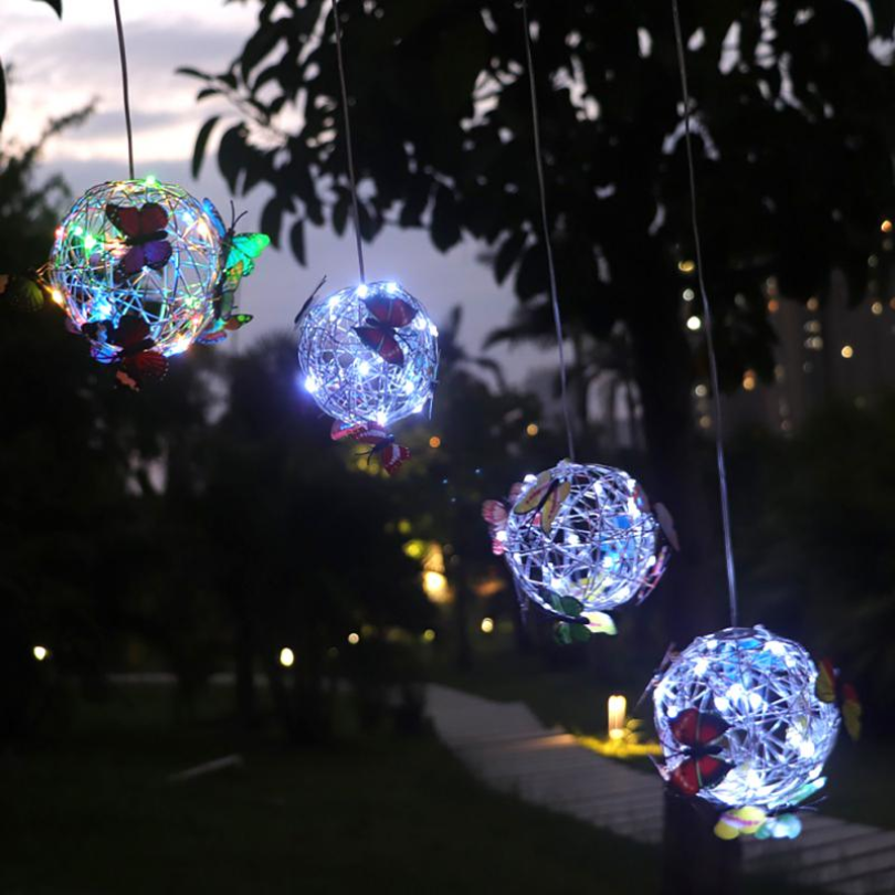 Nærbilde av dekorativ utendørs solcellelampe med detaljert sommerfugldesign. Perfekt hagebelysning.