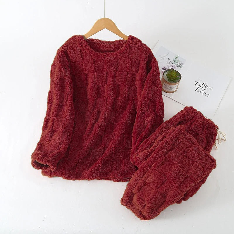 Kvinnelig modell smiler iført komfortabelt rutete pyjamassett i myk loungewear, perfekt for avslapping hjemme.