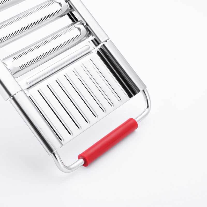 "Effektiv sølvfarget grønnsakskutter med fire utskiftbare kniver og ergonomisk håndtak for presis kutting."