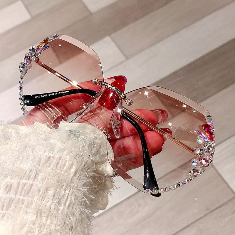 Detalj av glass på ramløs dame solbrille, med fokuserte rhinestones, UV400 beskyttelse.
