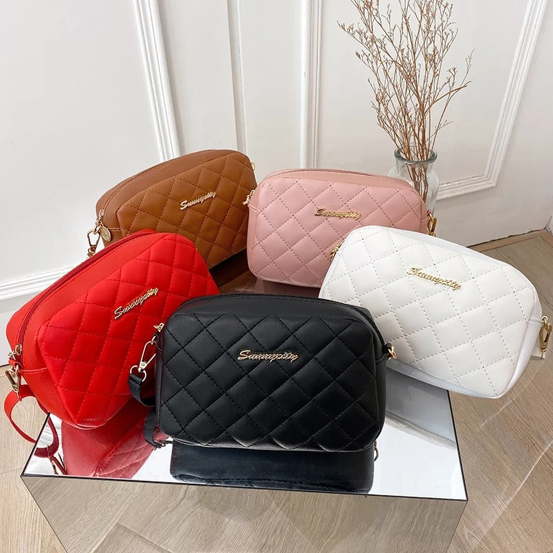 Teksturert quiltet veske i firkantet format med diskret diamantdesign og glidelås.