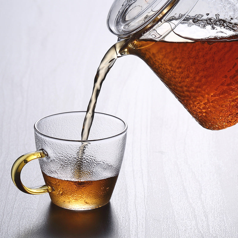 Transparent tekanne med infuser i rustfritt stål, viser teen vakkert ved brygging.