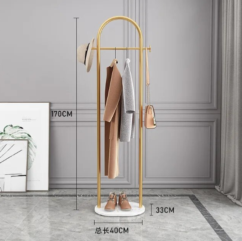 Gyllent klesstativ med tung marmorbase for stabilitet. Perfekt for elegant oppbevaring av klær i en luksusgarderobe.