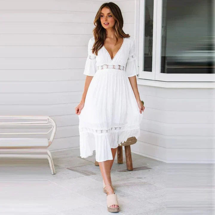 "Elegant midi-kjole med dyp V-hals, blondedetaljer og flare ermer, perfekt for sommeranledninger."