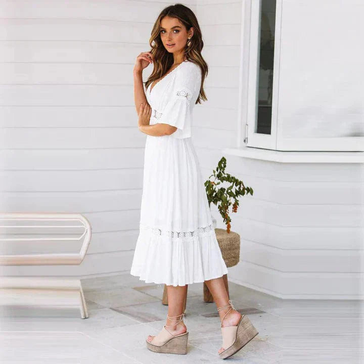 "Elegant midi-kjole med dyp V-hals, blondedetaljer og flare ermer, perfekt for sommeranledninger."