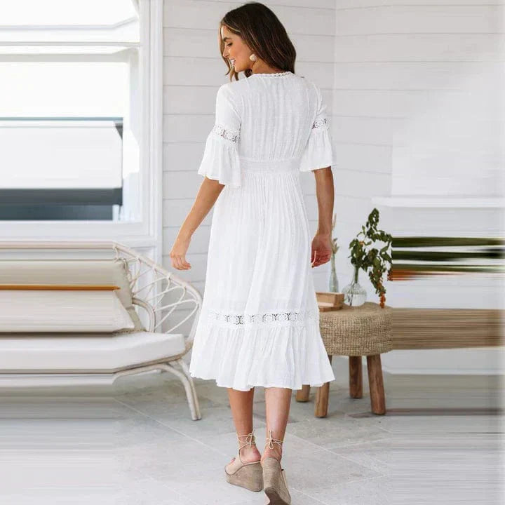 "Elegant midi-kjole med dyp V-hals, blondedetaljer og flare ermer, perfekt for sommeranledninger."