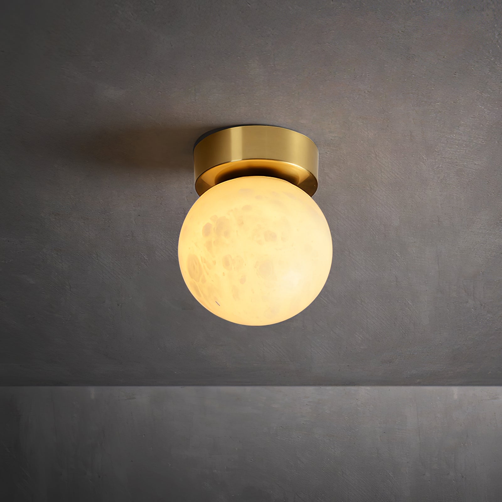 "Elegant Moon Alabaster taklampe i messing og alabast, med mykt, varmt lys for en innbydende atmosfære."