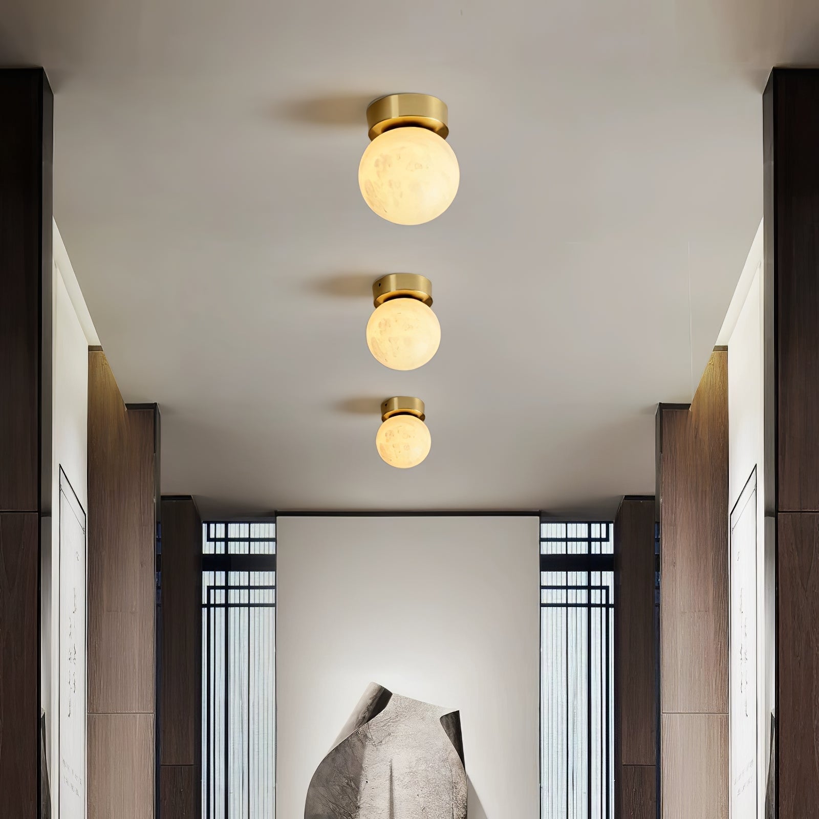 "Elegant Moon Alabaster taklampe i messing og alabast, med mykt, varmt lys for en innbydende atmosfære."