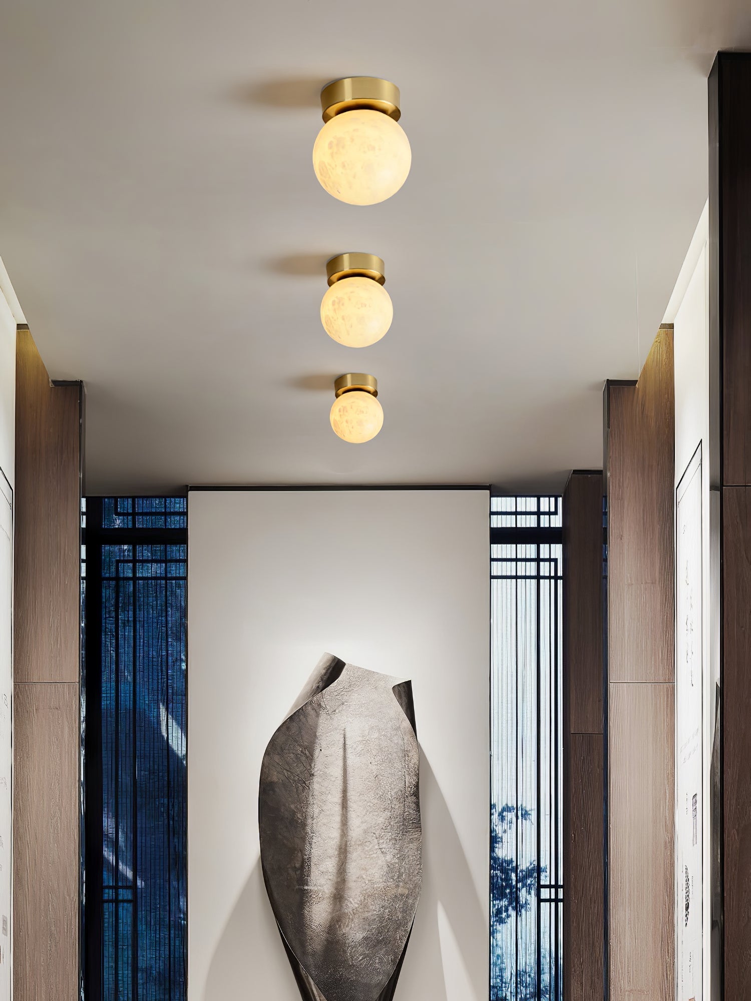 "Elegant Moon Alabaster taklampe i messing og alabast, med mykt, varmt lys for en innbydende atmosfære."