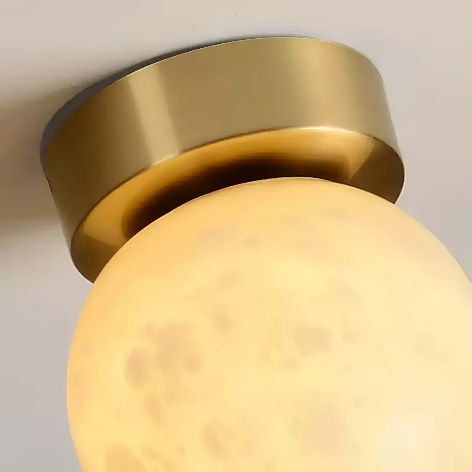 "Elegant Moon Alabaster taklampe i messing og alabast, med mykt, varmt lys for en innbydende atmosfære."