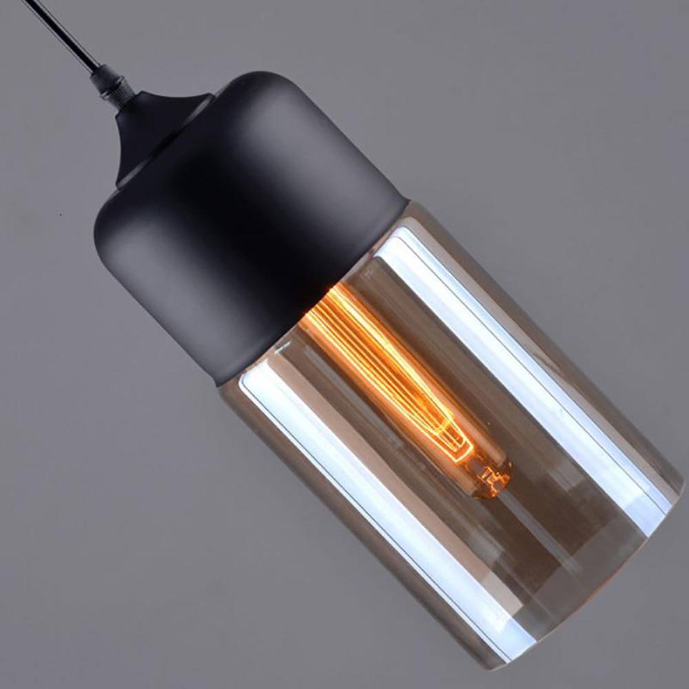 "Elegant pendellampe i håndblåst glass, justerbar, med transparent skjerm og svart snor for moderne interiørdesign."