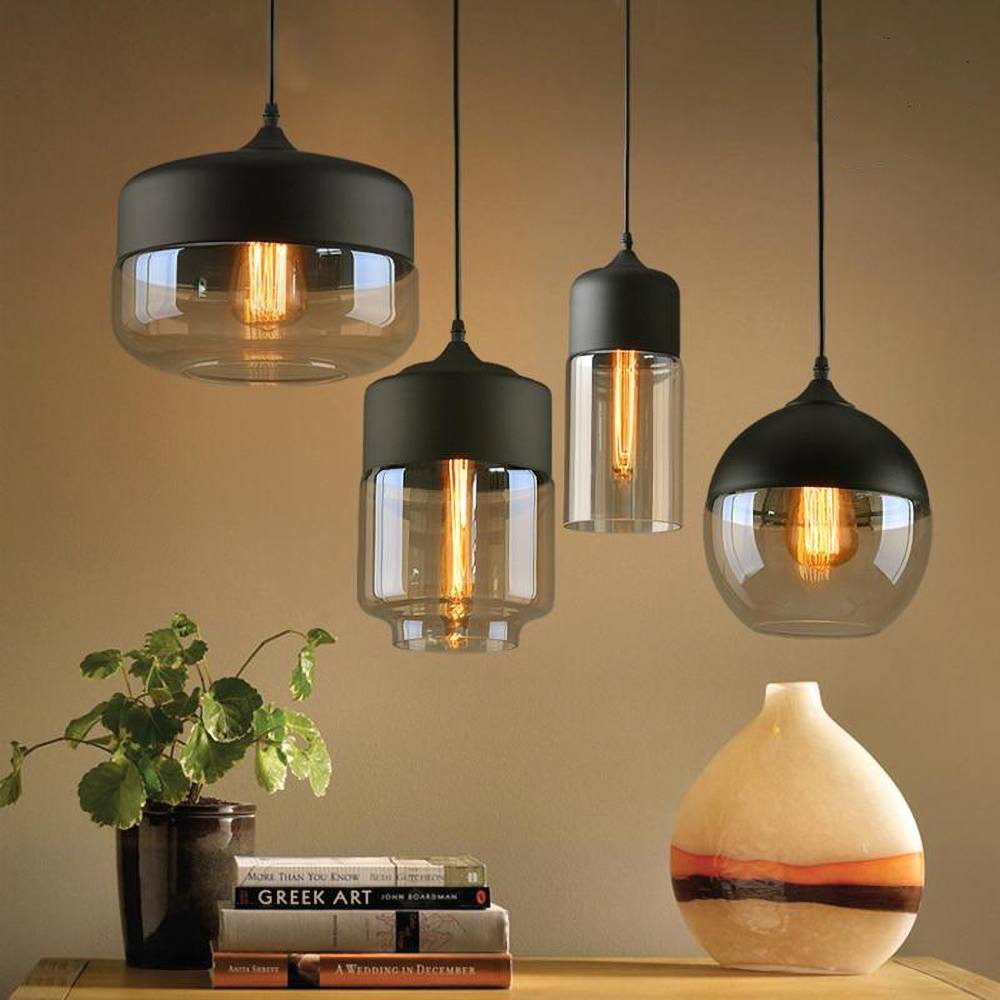 "Elegant pendellampe i håndblåst glass, justerbar, med transparent skjerm og svart snor for moderne interiørdesign."