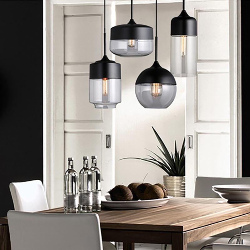 "Elegant pendellampe i håndblåst glass, justerbar, med transparent skjerm og svart snor for moderne interiørdesign."
