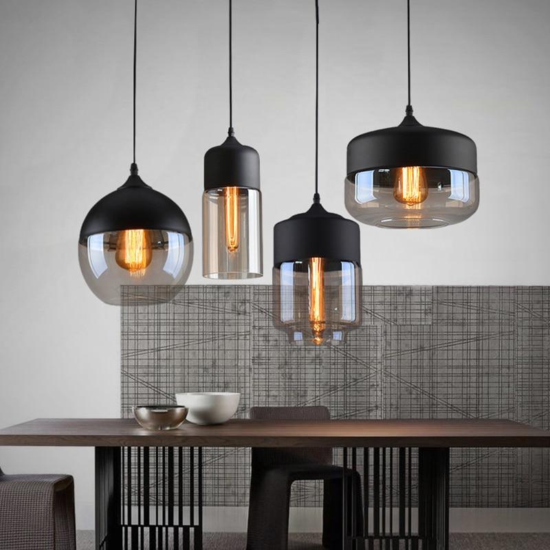 "Elegant pendellampe i håndblåst glass, justerbar, med transparent skjerm og svart snor for moderne interiørdesign."