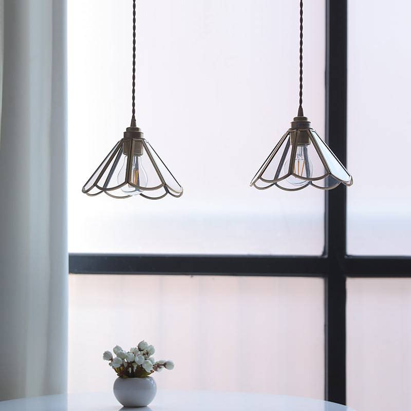 "Elegant pendellampe i messing og klart glass med vintage tvinnet stoffledning, gir en klassisk og moderne belysning."