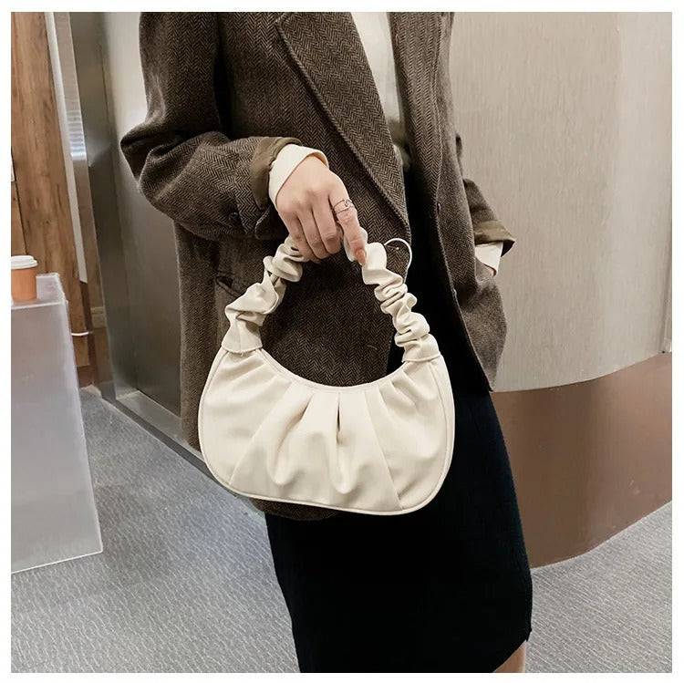 Moderne kvinne med plissert skulderveske i PU-skinn, fremhever trendy stil, moteveske