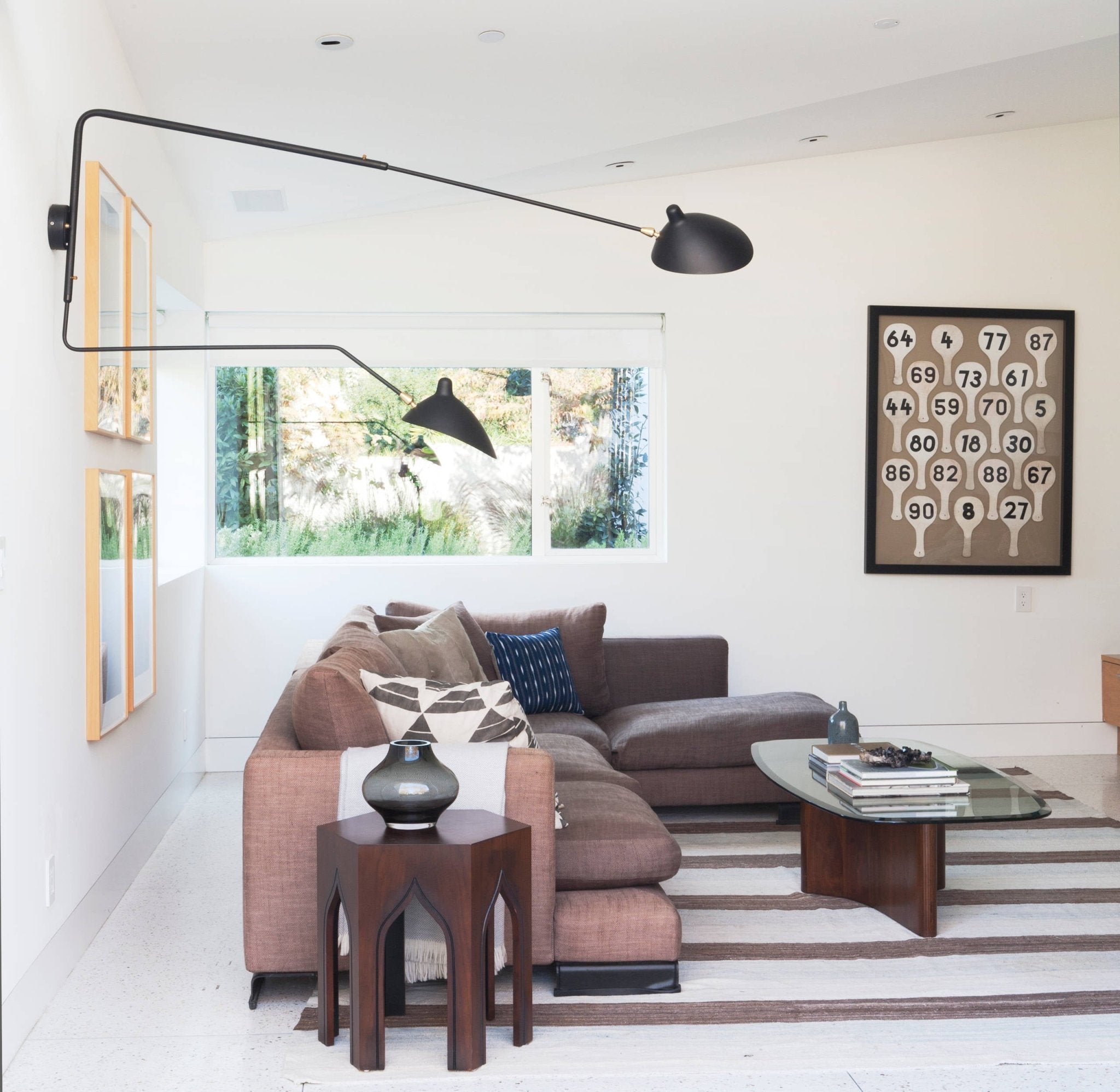 "Elegant Serge Mouille vegglampe med justerbar arm, insektlignende design, passer moderne innredning i svart eller hvit."