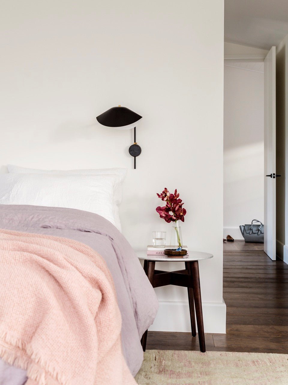 "Elegant Serge Mouille vegglampe med justerbar arm, insektlignende design, passer moderne innredning i svart eller hvit."