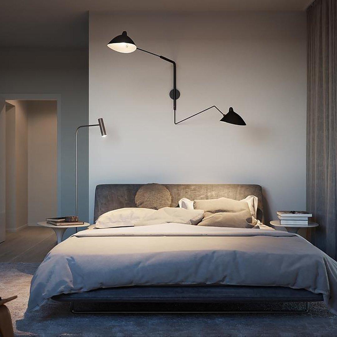 "Elegant Serge Mouille vegglampe med justerbar arm, insektlignende design, passer moderne innredning i svart eller hvit."