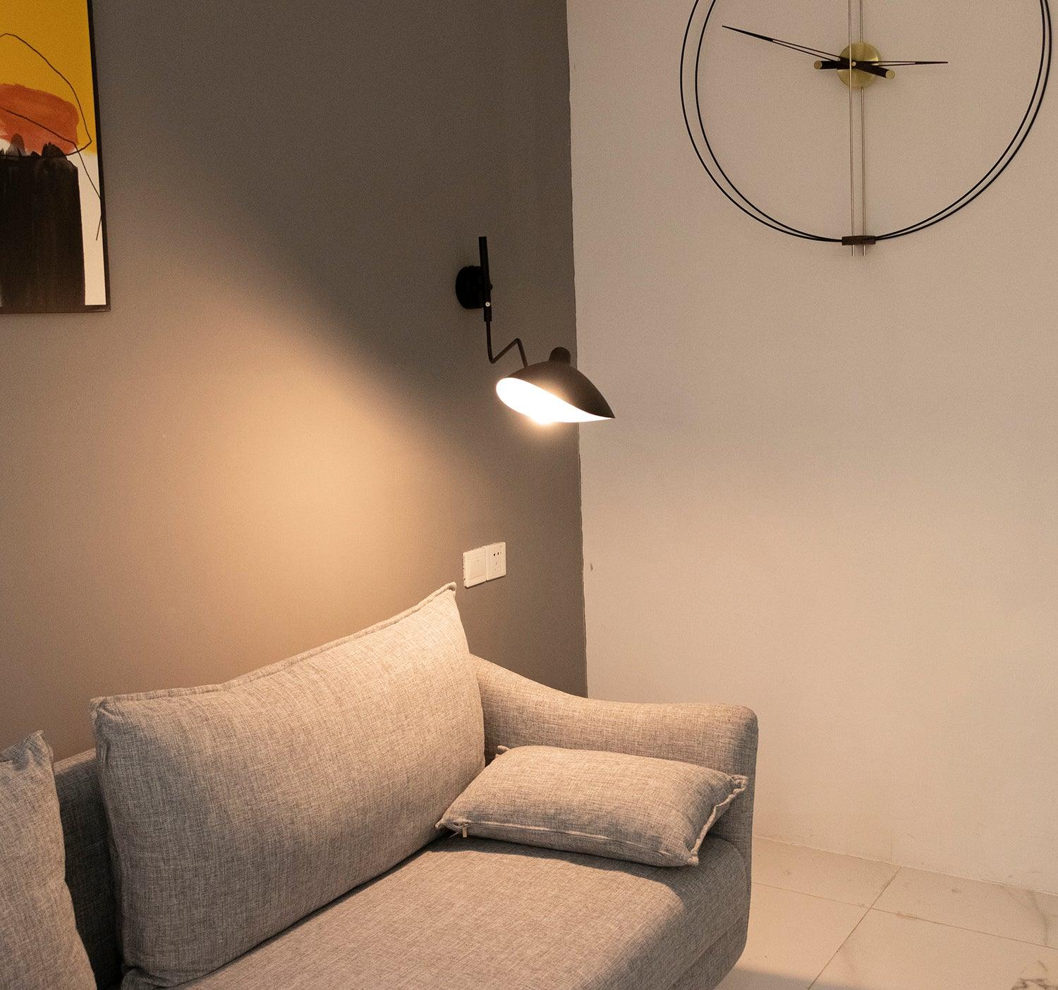 "Elegant Serge Mouille vegglampe med justerbar arm, insektlignende design, passer moderne innredning i svart eller hvit."