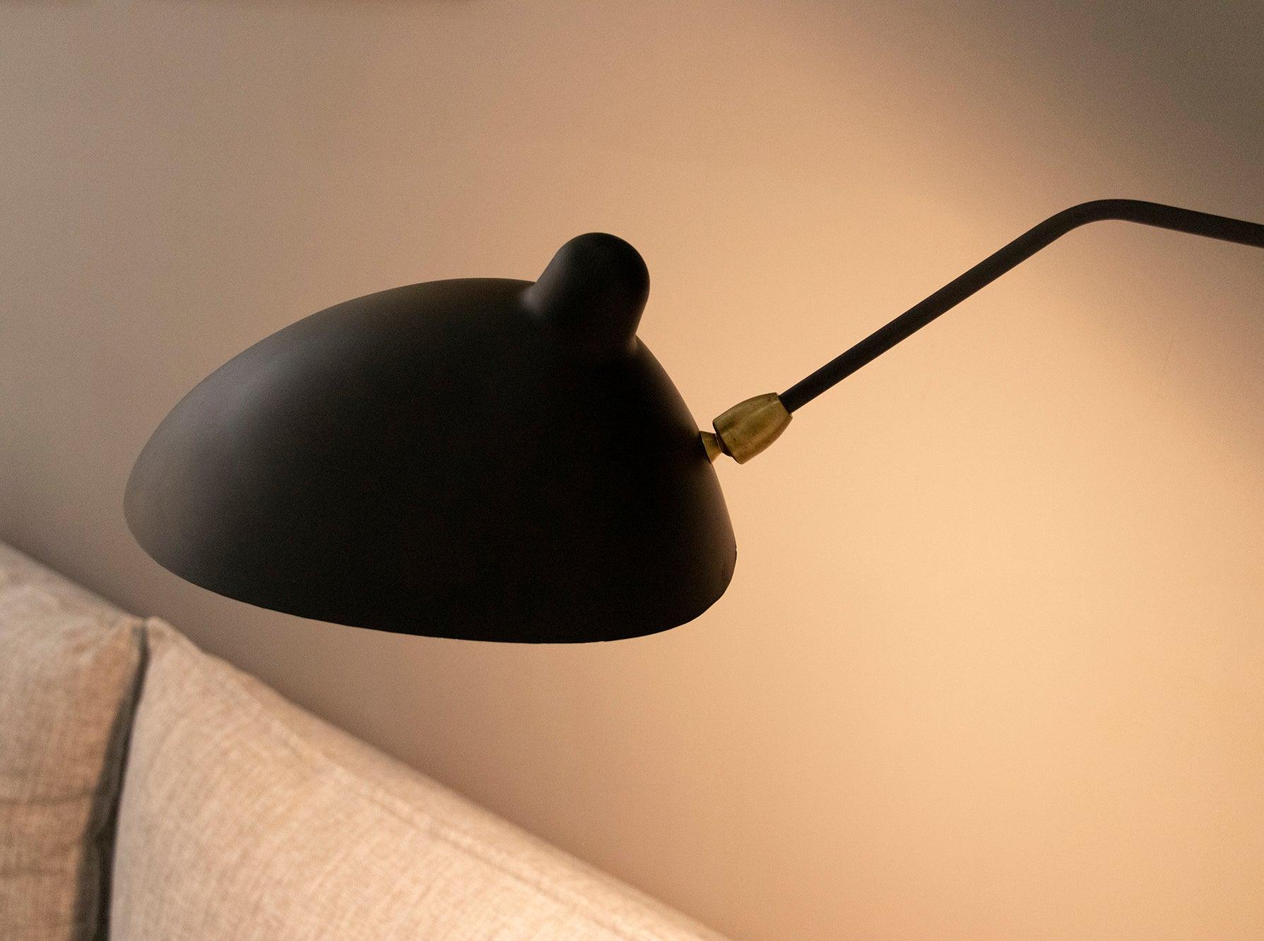 "Elegant Serge Mouille vegglampe med justerbar arm, insektlignende design, passer moderne innredning i svart eller hvit."