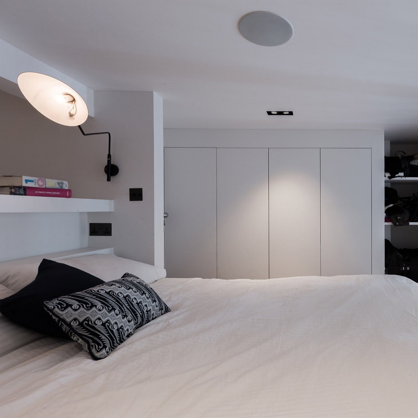 "Elegant Serge Mouille vegglampe med justerbar arm, insektlignende design, passer moderne innredning i svart eller hvit."