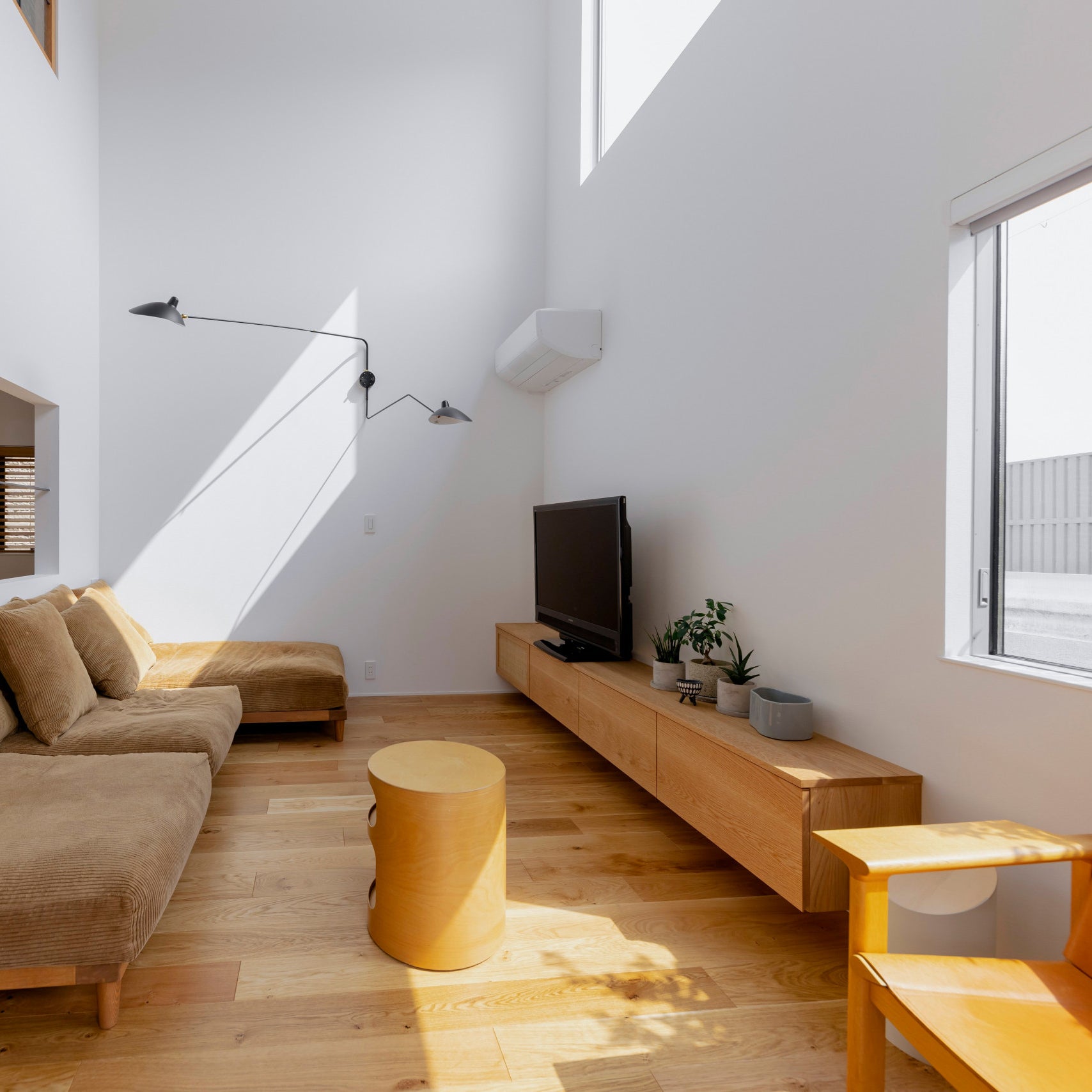 "Elegant Serge Mouille vegglampe med justerbar arm, insektlignende design, passer moderne innredning i svart eller hvit."